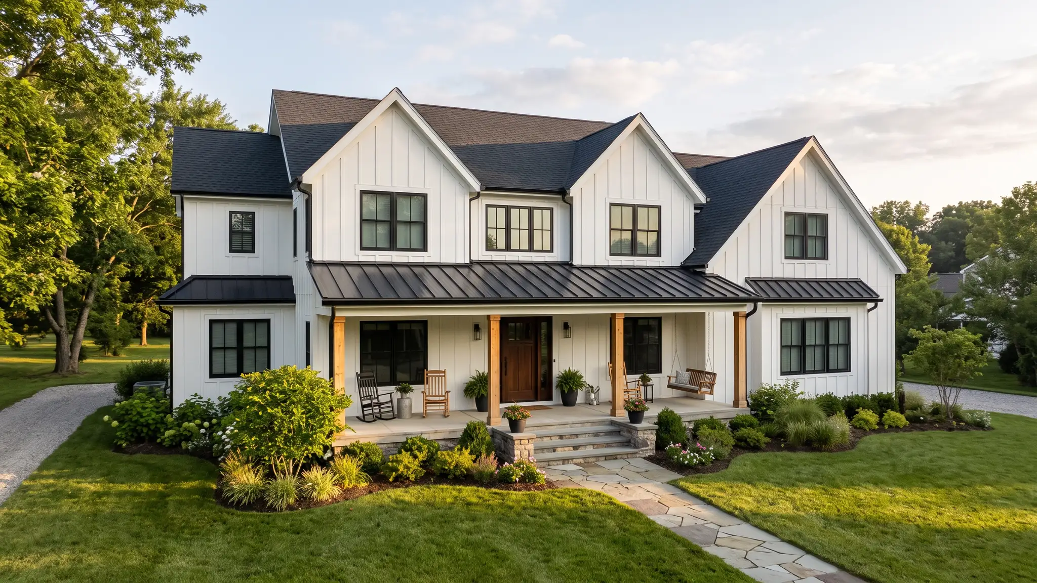 Modern farmhouse | Music City Siding A modern farmhouse style home with white board and batten siding, black windows, a metal roof accent and a wide front porch in soft morning light