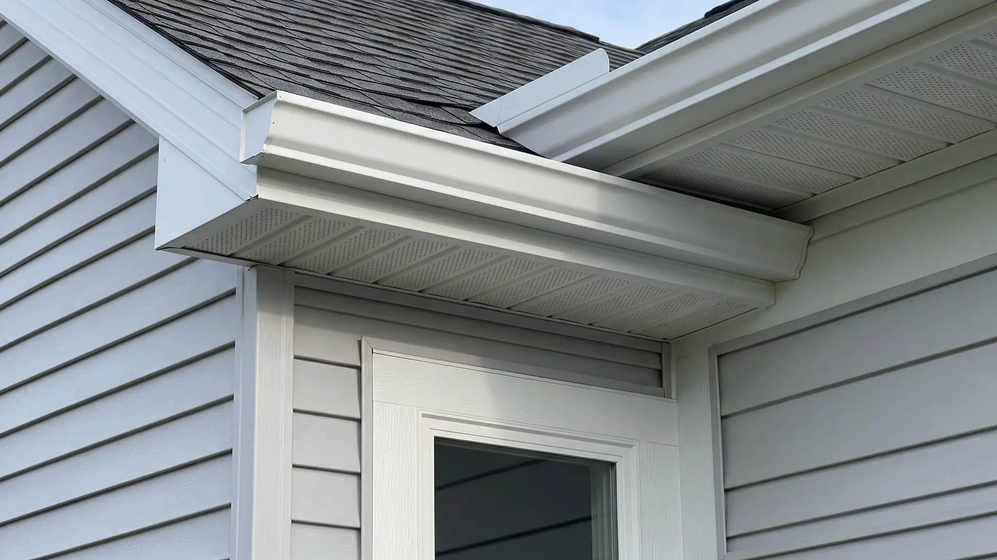 Trim, soffit and gutters | Music City Siding A close view of a roof edge with fresh white soffit, wrapped fascia, a seamless gutter and crisp window trim against new siding